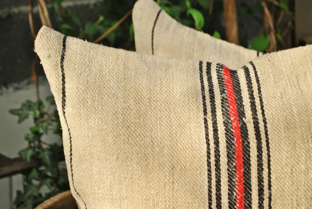 Square grain sack pillows, oatmeal handspun hemp, diagonal twill weave, centered stripe group, black and red woven lines, restored and hand-sewn in Transylvania